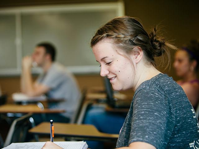 Female student takes notes in class